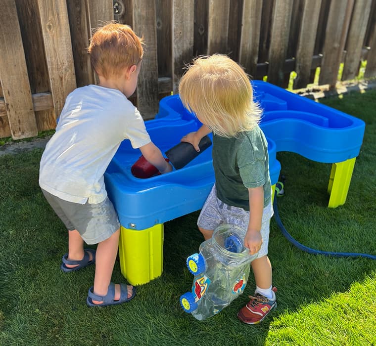 Children playing with water toys in a backyard setting